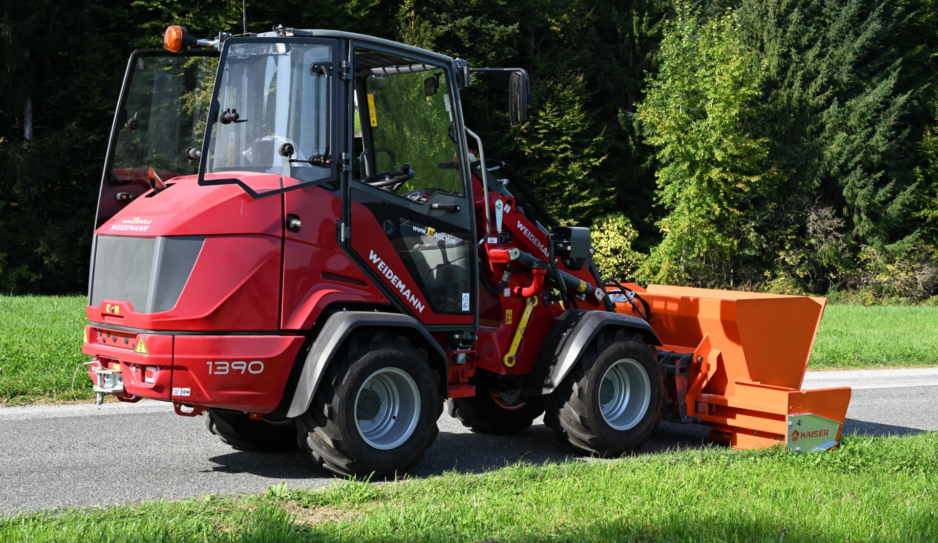 Kaiser Roadliner in Orange an einem Kommunaltraktor auf der Straße